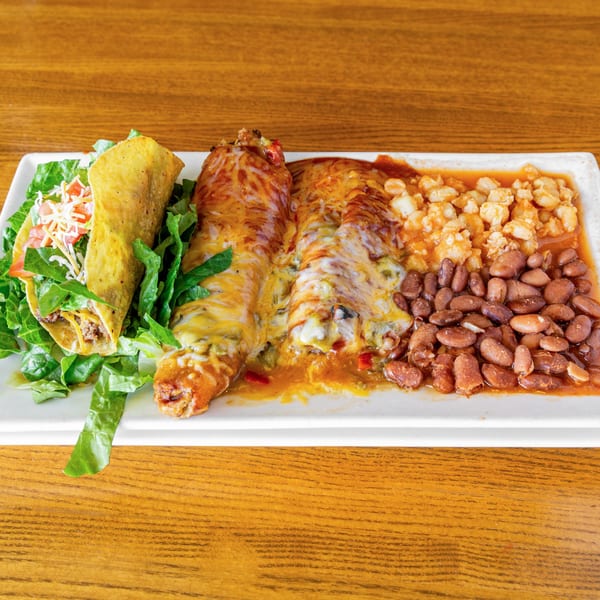 A Silver Moon Cafe Mexican combo plate with a taco, two enchiladas, beans, and hominy.